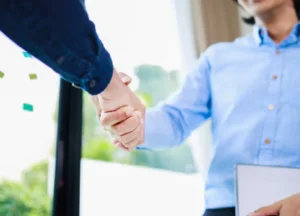 Business consultant shaking hands with a client during a meeting.