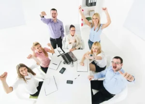 Happy sales team in a meeting celebrating successful results.