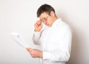 Businessperson holding a certificate up to the light, examining closely