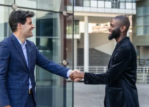 Two business professionals shaking hands in a competitive or decision-making scenario.

