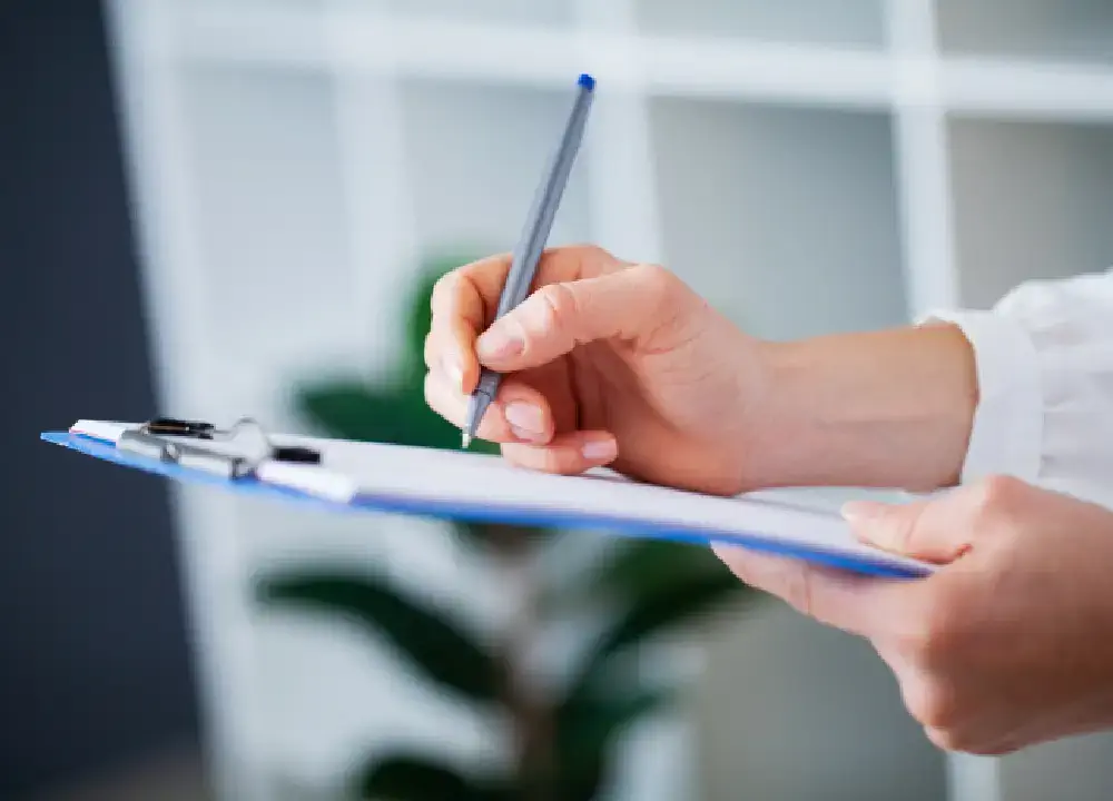 Employee reviewing an ISO audit checklist with a pen in hand