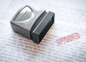 Stamp labeled “Approved” or “Certified” being placed on a document