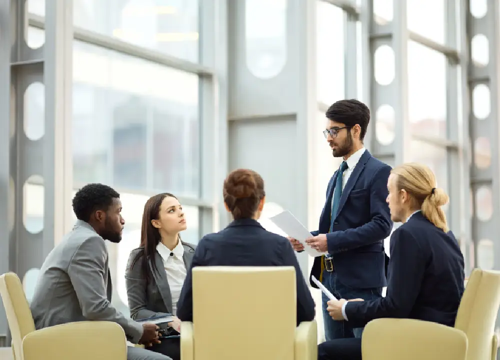 meeting or brainstorming session with professionals from different departments (e.g., IT, HR, operations) around a table or digital display — shows cross-functional value.