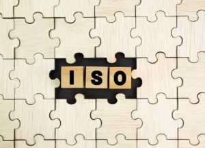 Wooden puzzle pieces forming the word "ISO" – symbolizing standardization and quality systems.