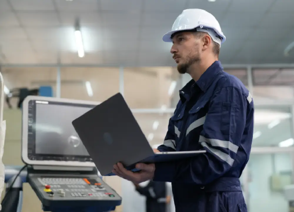 Engineer or facility manager inputting data into a laptop onsite

