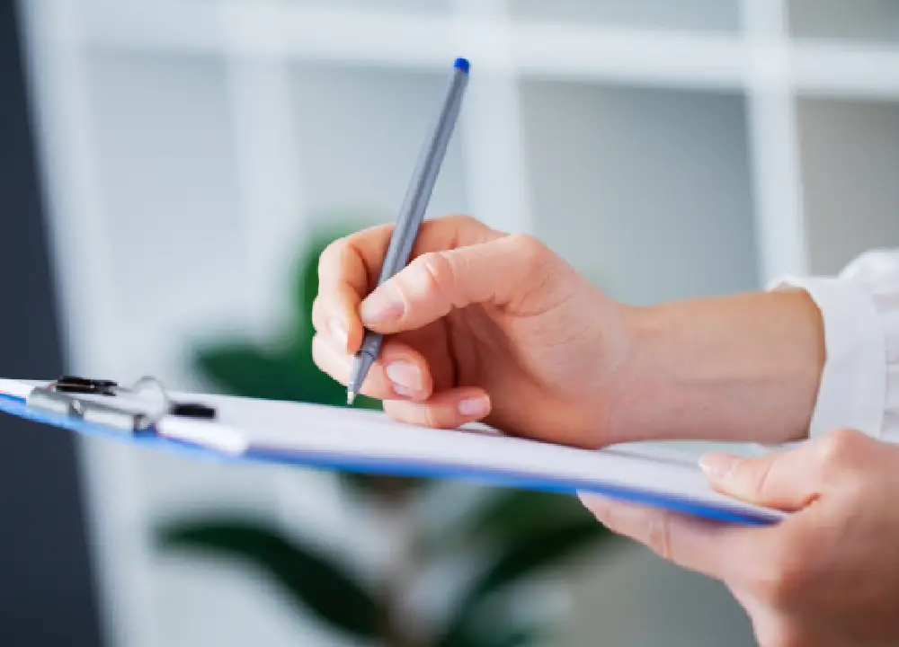 Close-up of hands reviewing a quality management checklist or audit form.
